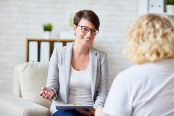 Psychologin sitzt mit einer Patientin in einer Beratung, um ihr zu helfen