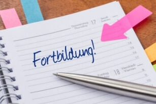 Ein Notizkalender ist zu erkennen, auf dessen aufgeschlagene Seite groß das Wort "Fortbildung" zu lesen ist