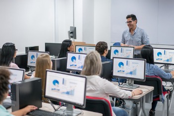 Berufsbegleitend Studierende lernen im Seminarraum an PCs.