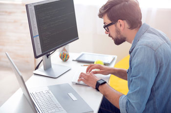 Ein Fernstudent der Informatik sitzt am Rechner und lernt