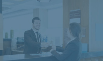 Hotelmanager reicht einer Kundin ihre Zimmerkarte