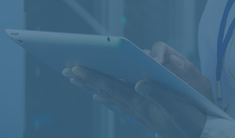 Hände, die ein Tablet halten und darauf tippen