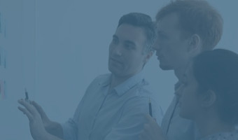 Drei Kollegen brainstormen und heften Notizen an eine Glasscheibe