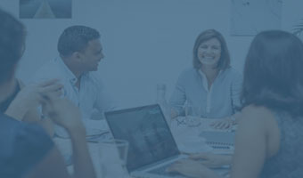 An einem Schreibtisch arbeiten vier Kulturmanager.