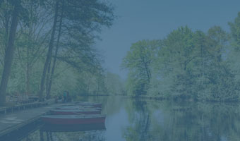 Ein Park mit Blick auf den See und einigen Ruderbooten am idyllischen Ufer