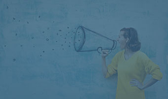 Eine junge Frau schreit durch ein, auf die Wand hinter ihr, gemaltes Megaphon.