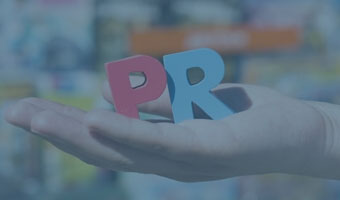 Eine Hand, die den roten Buchstaben P und den blauen Buchstaben R hält.