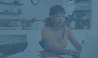 Junge Frau arbeitet in der Küche am Laptop